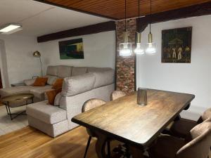 ein Wohnzimmer mit Tisch und Couch in der Unterkunft Arbide, caserio tradicional vasco en Carranza in Karrantza + 11 Fotos