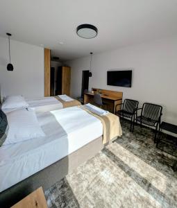 a hotel room with two beds and a desk at Hotel Eden in Rzgów +19 photos