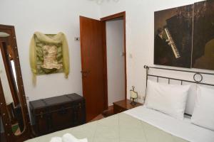 a bedroom with a bed and a door with a picture at ΑΡΣΙΝΟΗ apartments1 in Mesochórion