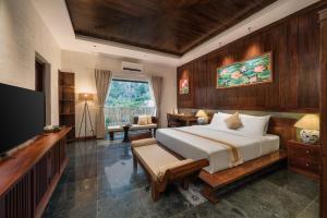 a bedroom with a large bed and a desk at The Greenary Garden in Ninh Binh