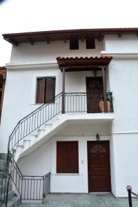 a white house with a staircase and two doors at ΑΡΣΙΝΟΗ apartments1 in Mesochórion