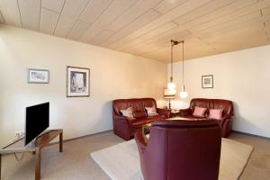 a living room with two leather chairs and a tv at Ferienwohnung Matteit in Bad Peterstal