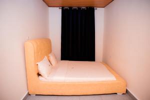 ein kleines Zimmer mit einem Bett und einem schwarzen Vorhang in der Unterkunft The Moon Geust House in Gisenyi