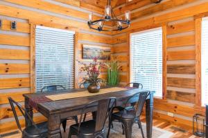 a dining room with a wooden table and chairs at Hot Tub & WiFi - Big Boulder - Red River Gorge KY in Rogers