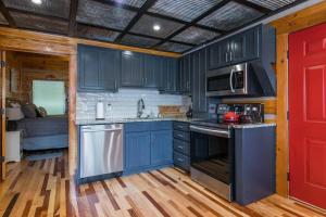 a kitchen with blue cabinets and a red door at Hot Tub & WiFi - Big Boulder - Red River Gorge KY in Rogers