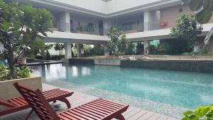 een zwembad met 2 stoelen en een gebouw bij Marbella in Kuala Lumpur +18 foto's