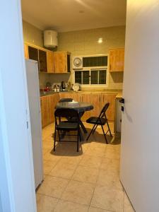 a kitchen with a table and chairs in it at ريحانة الورود للشقق المخدومة -Golden New in Khamis Mushayt