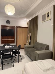 a living room with a couch and a table at ريحانة الورود للشقق المخدومة -Golden New in Khamis Mushayt