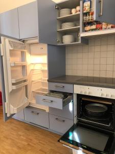 a kitchen with an open refrigerator and an open oven at Wonderful apartment in the historic center in Bellinzona