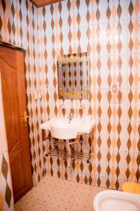 ein Badezimmer mit Waschbecken und Spiegel in der Unterkunft The Moon Geust House in Gisenyi + 20 Fotos
