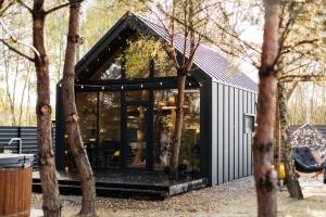 a modern house with glass doors in a forest at Forest Vibe Hotel&Spa in Kulʼchin