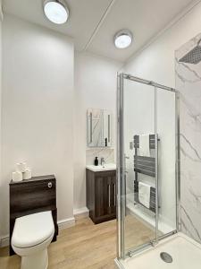 a bathroom with a shower and a toilet and a sink at Spacious Central Ground Floor Apartment Sleeps 6 - Newark Town Centre - Free Parking - Amaya Twelve in Newark upon Trent