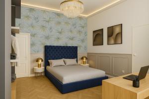 a bedroom with a blue bed and a desk at Incanto Relais & Charme - dBe Hotels in Florence