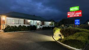 una señal de motel frente a un edificio por la noche en Motel Homestead, en Auckland 27 fotos más