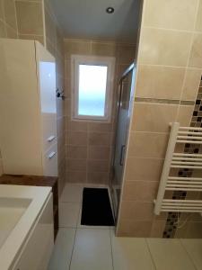 a bathroom with a shower with a window at Villa détente - Entre terre et mer in Le Gué-dʼAlléré