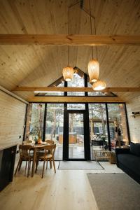 a living room with a table and a large window at Forest Vibe Hotel&Spa in Kulʼchin