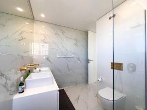 a white bathroom with a sink and a toilet at Beira Mar, Portimão com Garagem e Piscina in Portimão +40 photos