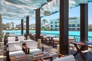a patio with tables and chairs and a pool at Marassi Boutique Hotel-Blanca in El Alamein