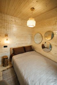a bedroom with a bed in a wooden wall at Forest Vibe Hotel&Spa in Kulʼchin