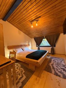 a bedroom with a large bed and a wooden ceiling at Cabana Arini 1954 in Vişeu de Jos
