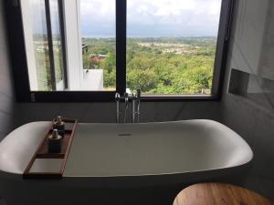 a white bath tub in a bathroom with a window at M Villa in Bingin Beach