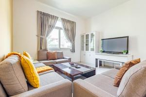 Una sala de estar con dos sofás y un televisor. en Peaceful and Spacious 2 BDR in the Heart of Al Ghadeer Community, en Ghantoot