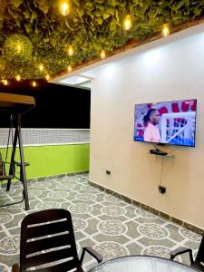 a flat screen tv on a wall in a room at Modern 3-Story Condo with Private Rooftop Lounge in Amasaman