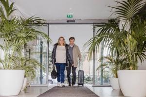 莫尔Corbie Mol的带着手提箱在机场走的男人和女人