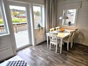 a dining room with a table and chairs and a balcony at Färjas Brygga in Söråker