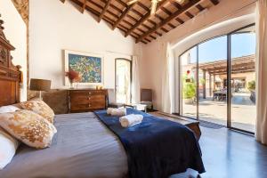 a bedroom with a large bed and a large window at Masia Notari Casabona in Vilanova i la Geltrú +36 photos