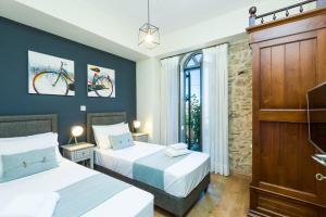 1 dormitorio con 2 camas y una bicicleta en la pared en Philoxenia Apartments, en Panormos Rethymno 70 fotos más