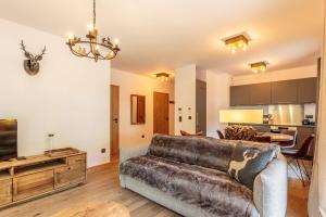 a living room with a couch and a kitchen at Tome, superbe appartement avec terrasse vue montagne in Champagny-en-Vanoise