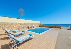 eine Villa mit einem Pool und 2 Liegestühlen in der Unterkunft The Cottage South Escape with beach front pool in Plimmiri