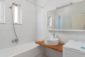 ein weißes Badezimmer mit Waschbecken und Spiegel in der Unterkunft The Cottage South Escape with beach front pool in Plimmiri