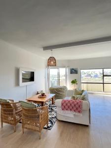 a living room with a couch and chairs and a table at Atlantic Apartment - spacious kite accommodation in Langebaan