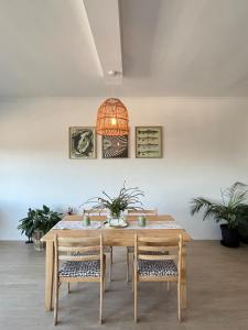 a dining room table with chairs and a light fixture at Atlantic Apartment - spacious kite accommodation in Langebaan
