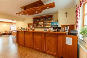 a restaurant with a bar with wooden cabinets at Penzión Pod Babou in Omšenie