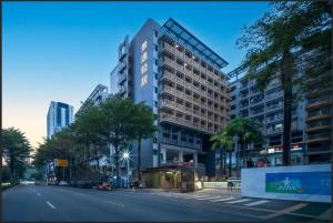 a large building on a street in a city at Jingyi Qingju Executive Apartment in Shenzhen