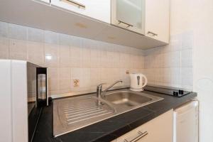 Una cocina con un fregadero de acero inoxidable en una cocina. en Apartment Vesna A2, en Ika 16 fotos más