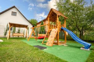 a playground with a slide and a play house at Penzión Pod Babou in Omšenie