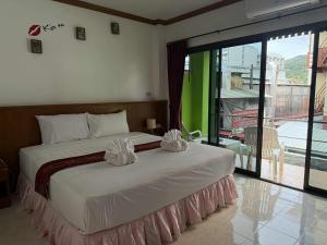 a bedroom with a bed with two white pillows on it at Flowernight Guesthouse in Kata Beach