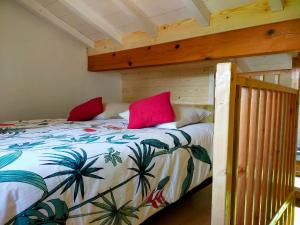 een slaapkamer met een bed met twee rode kussens erop bij goitik ikusita in Aïnhoa