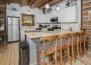 una cucina con armadi bianchi e un'isola con sgabelli da bar di Timbercreek #8B Condo a Vail