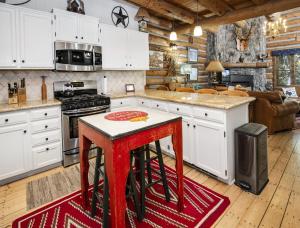 una cucina con armadi bianchi e uno sgabello rosso di Timbercreek #8B Condo a Vail