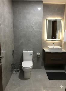 a bathroom with a white toilet and a sink at Govinda Hall in Kānpur