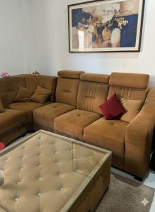 a living room with a brown couch and a coffee table at Govinda Hall in Kānpur