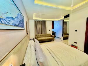 Una habitación de hotel con una cama grande y un sofá. en 1260 Lumaana Residence, en Garki