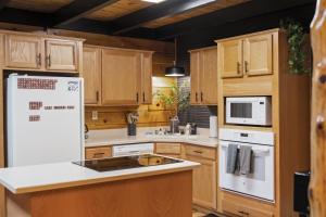 a kitchen with white appliances and wooden cabinets at Hot Tub & WiFi - Hillside Haven Red River Gorge KY in Rogers