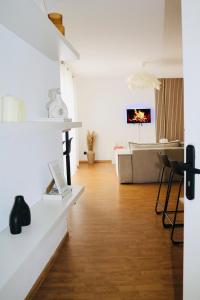 - un salon avec des murs blancs et un canapé dans l'établissement Charmant appartement STRASBOURG, à Strasbourg