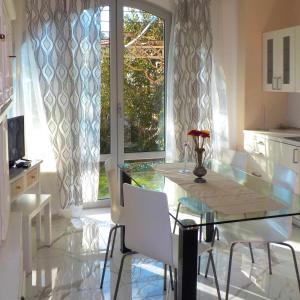 a dining room with a glass table and white chairs at Villa sur mer, chez Angelina in Grimaud